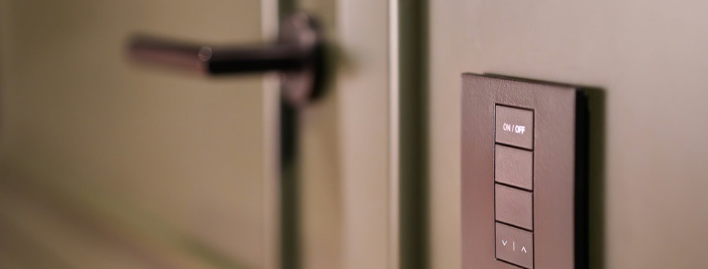 Wall-mounted smart lighting keypad beside a door
